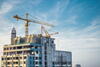 Crane with construction and cloudy sky